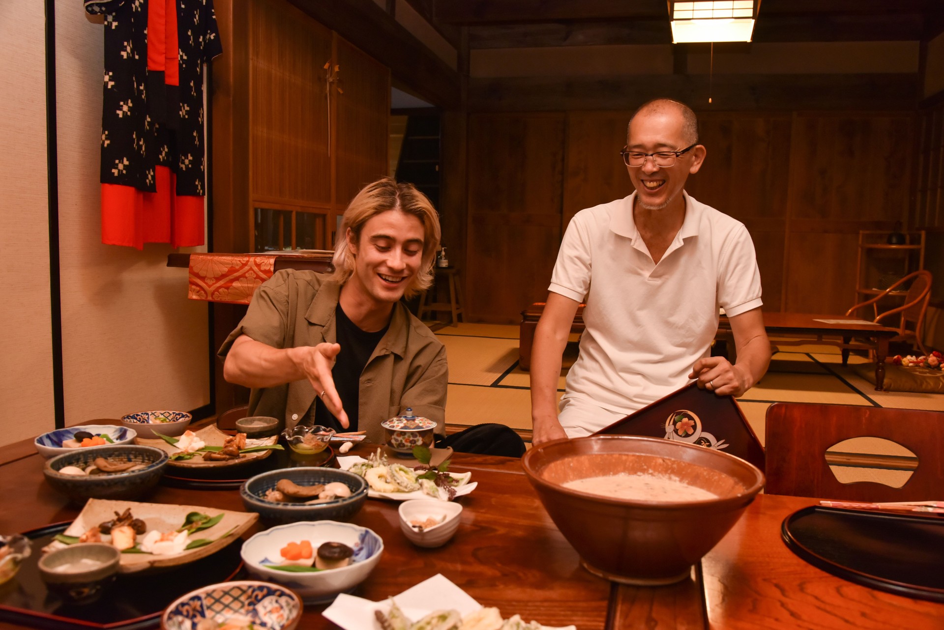 Japanese small business owner bringing food to tourist in Japan and explaining about food - stock image